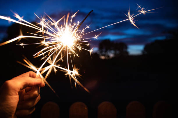 istock Hand holding a burning sparkler at blue hour. 1718185798