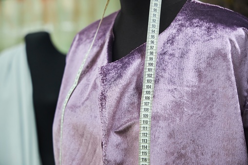 A mannequin in an atelier with clothes not sewn to the end. The concept of hobbies and crafts.