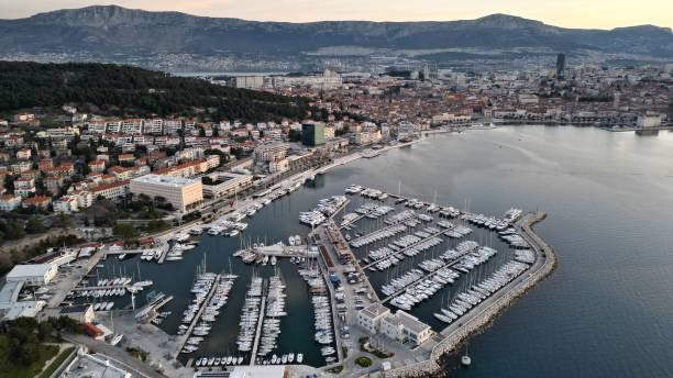 un puerto deportivo dividido en dos filas junto al agua - harborage fotografías e imágenes de stock