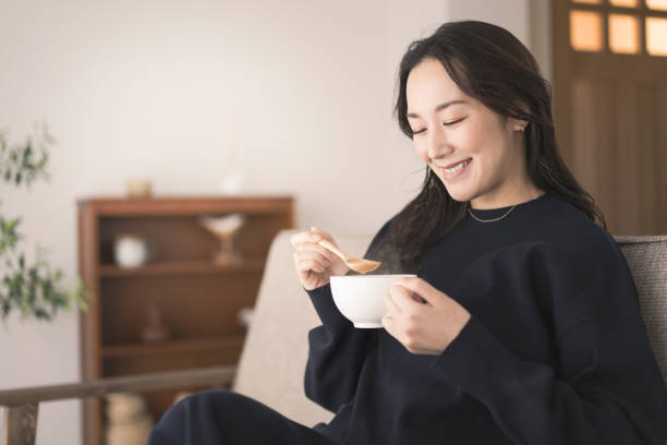 istock A woman is drinking hot soup. 1718228374