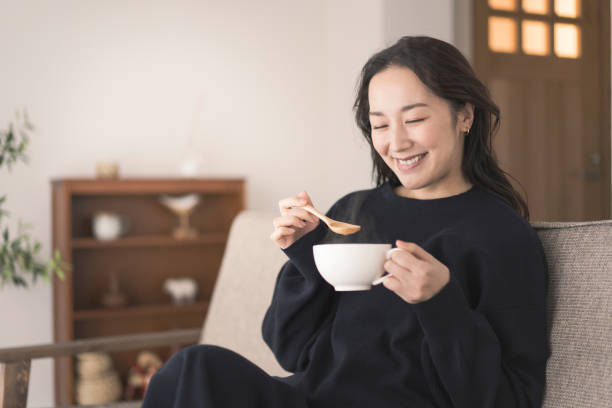 istock A woman is drinking hot soup. 1718228386