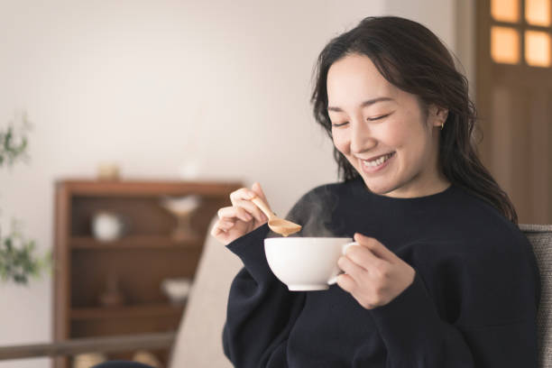istock A woman is drinking hot soup. 1718228387