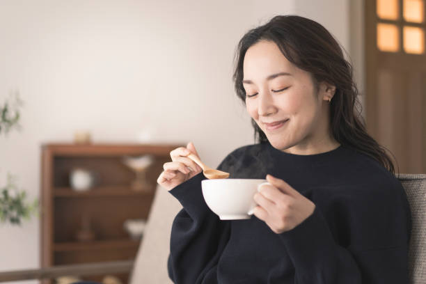 istock A woman is drinking hot soup. 1718228390