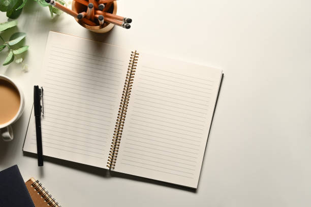 istock Blank spiral notebook, pencil holder and coffee cup on white table. Top view with copy space for text 1718264263