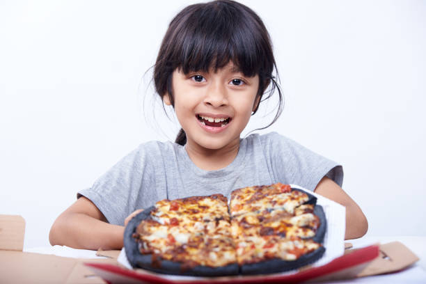 śliczna dziewczynka trzyma czarną pizzę na białym tle - convenience food box humor zdjęcia i obrazy z banku zdjęć