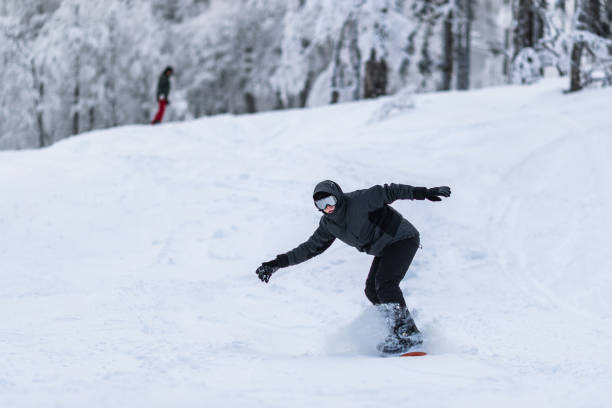 istock Man having fun while snowboarding in winter day on a mountain. 1718286321