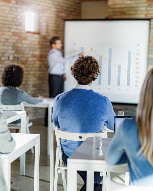 istock Back view of entrepreneur on a seminar in board room. 1718303436