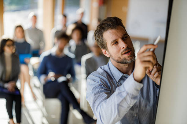 istock Male presenter writing plans during presentation in the office. 1718311354