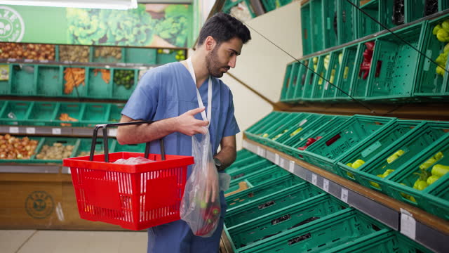 Man in Medical Scrubs, customer and grocery shopping cart in supermarket store, retail outlet or mall shop.