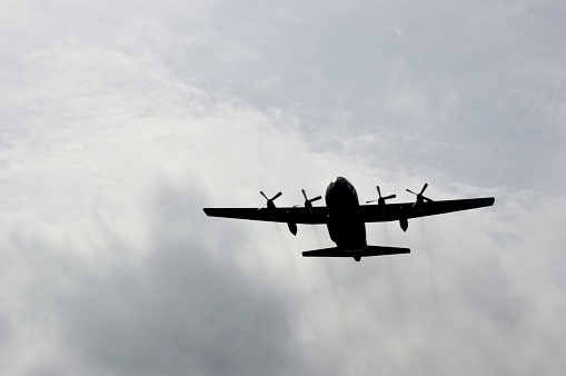 Biplane landing with cloudy sky on the background.