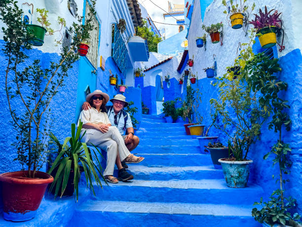 Mature couple posing on stairway in Chefchaouen, Morocco Mature couple posing on stairway in Chefchaouen, Morocco. The colorful blue walls of the city make this a unique city. chefchaouen stock pictures, royalty-free photos & images