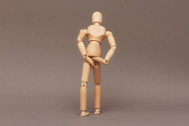 istock Wooden man standing with his back showing bowel and bowel problems. 1718338919