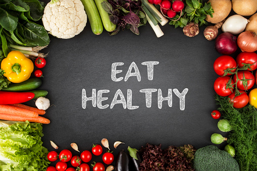 Organic vegetables with eat healthy message on blackboard background