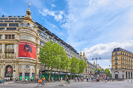 Paris, France - July 12, 2023: Pedestrians and traffic on Boulevard Haussmann in front of the Printemps department store.