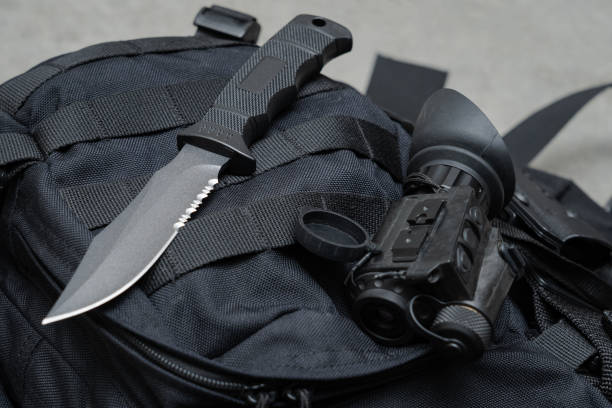 istock Night vision device and pen knife on the black tactical backpack 1718359128