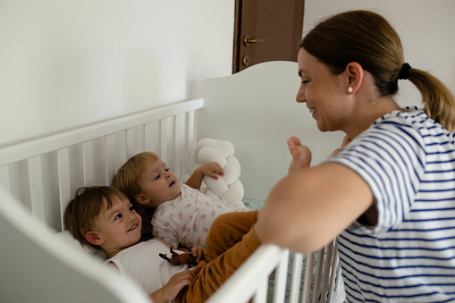 Twins are playing with their mom