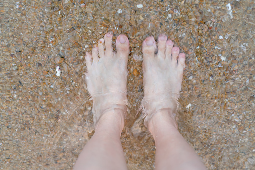 beautiful feet and sand in motion on a tropical beach