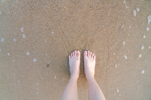 feet standing on the beach