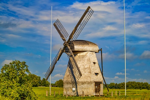Russia, Veliky Novgorod - August 20, 2023: Windmill in a field against a blue sky
