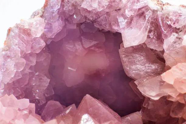 Macro focused vibrant pink amethyst quartz geode crystal, rose hematite amethyst points isolated