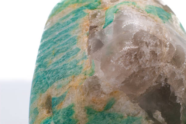istock A tumbled chunk of light green and blue amazonite crystal with a clear quartz matrix focused and isolated on a white surface background 1718418612