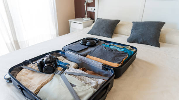 istock Suitcase with camera and clothes prepared for travel 1718433443
