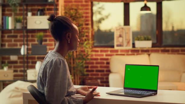 istock Woman waves at greenscreen on pc 1718439474
