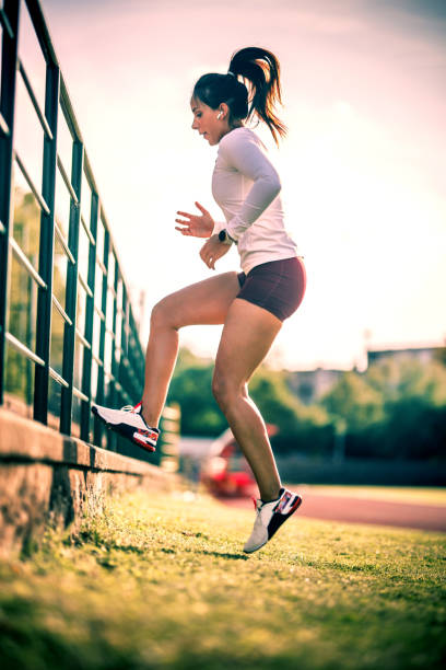 young woman exercising outside young woman exercising outside running shorts stock pictures, royalty-free photos & images