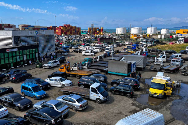 estacionamento com veículos de carga e passageiros perto das estruturas portuárias na costa do mar negro em batumi. - beach parking lot car equipment - fotografias e filmes do acervo