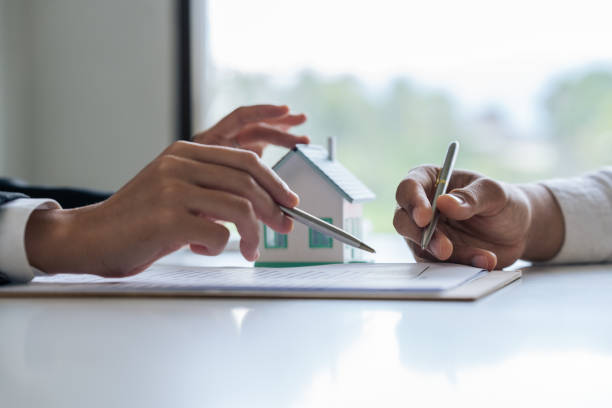 istock Professional real estate agent guiding and explaining the document process to the customer 1718449059
