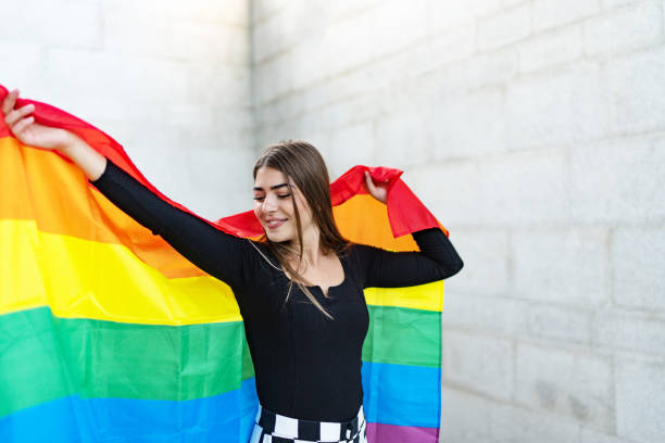 istock Confident beautiful woman holding rainbow flag 1718461919