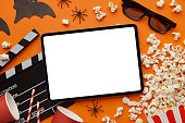 Striped box with popcorn and tablet on an orange background