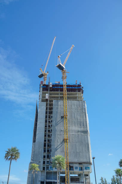 istock Construction site background. Hoisting cranes and new multi-storey buildings. Industrial background. Building construction site work against blue sky. 1718475136