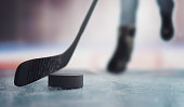 Hockey player is skating with puck on ice at stadium. 3D rendered illustration.