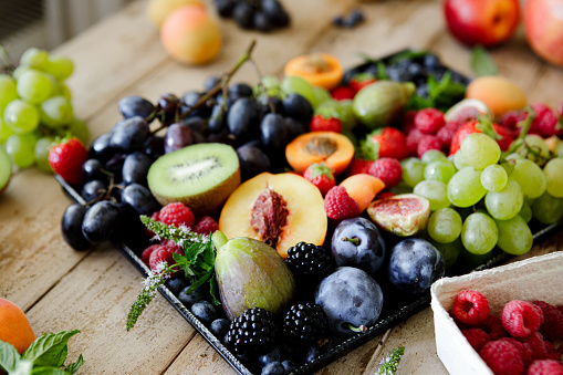 Different types of fruits in tray on the table. Variety of fresh and healthy fruits.