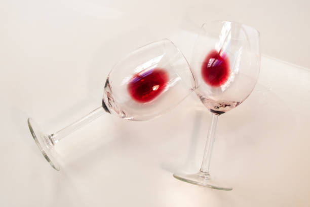istock Two half empty glasses glasses of red wine on a white background 1718524284