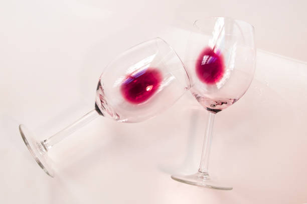 istock Two half empty glasses glasses of red wine on a white background 1718524802