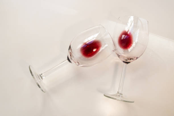 istock Two half empty glasses glasses of red wine on a white background 1718534979