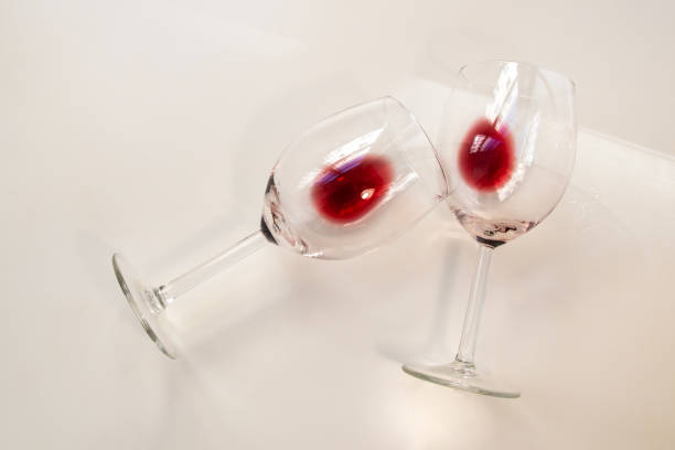 istock Two half empty glasses glasses of red wine on a white background 1718536751