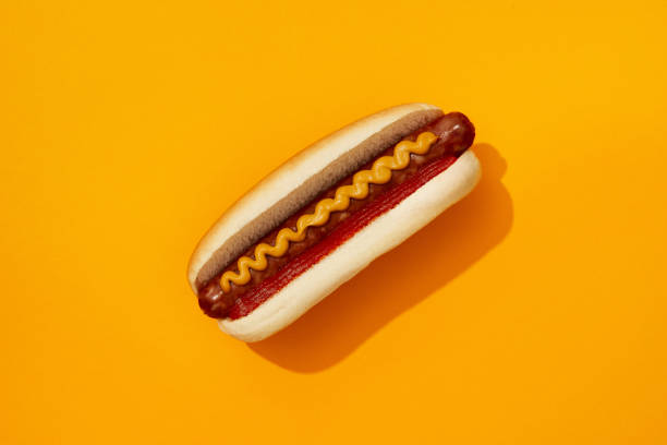 istock Classic hot dog with wurst, ketchup and mustard on orange background. Restaurant menu 1718539577