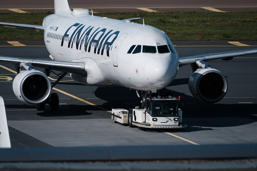 Helsinki / Finland - SEPTEMBER 7, 2023: Helsinki-Vantaa Airport EFHK. An Airbus A320, operated by Finnair, being pulled by an aircraft tug.