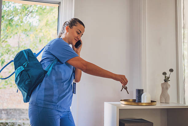 Female nurse going to work from home and taking keys to lock the house stock photo