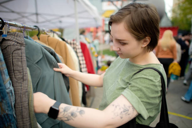 istock Young woman choosing second hand clothes at a flea market. Zero waste and sustainable lifestyle concept. 1718600401