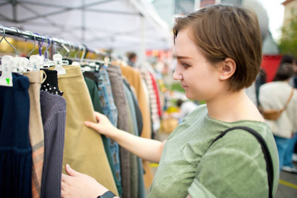 istock Young woman choosing second hand clothes at a flea market. Zero waste and sustainable lifestyle concept. 1718600418