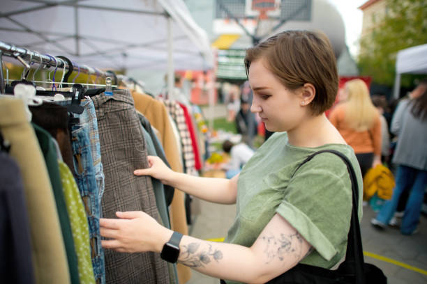 istock Young woman choosing second hand clothes at a flea market. Zero waste and sustainable lifestyle concept. 1718600421