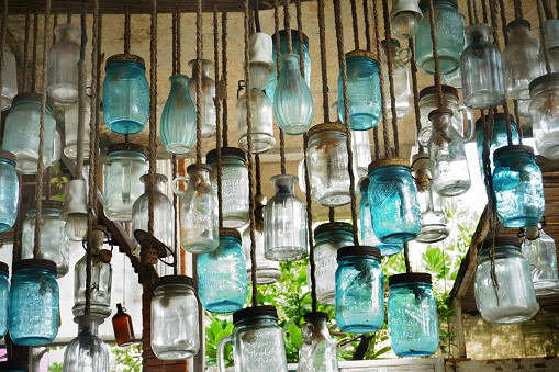 Decorating with vintage-style glass bottles, hanging metal lanterns, and aged artifacts adds a touch of nostalgia and elegance to the space.