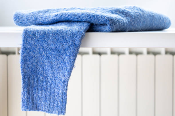 istock Wool sweater drying on a heating radiator at home in winter. 1718614466