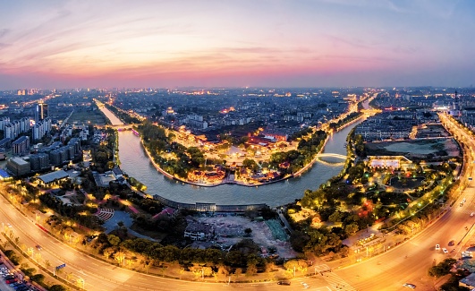 An aerial view of the city of Yangzhou in China, featuring Dashuiwan Park, Beijing-Hangzhou Grand Canal and the skyline illuminated by night lights