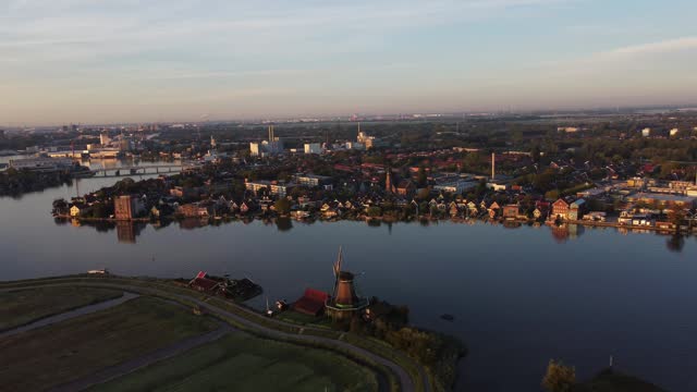 Aerial shot of the peaceful Zaam River and the village of Zaandijk in the morning sun. The awakening of humanity. 4k video