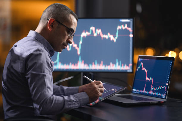 istock Man Checking His Stock Market Exchange Investment Using His Laptop Computer At Night. 1718646209